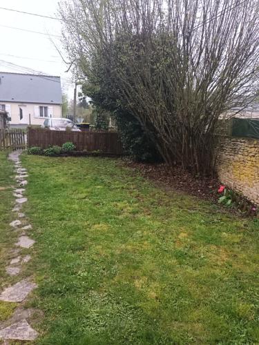 a yard with a bush next to a brick wall at D'une rive à l'autre in Francueil