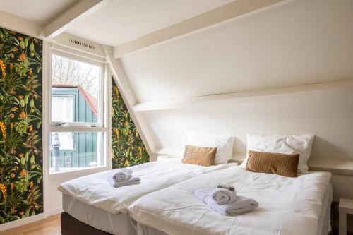 a bedroom with a large white bed with towels on it at Tulip Marina in Nieuwe-Niedorp