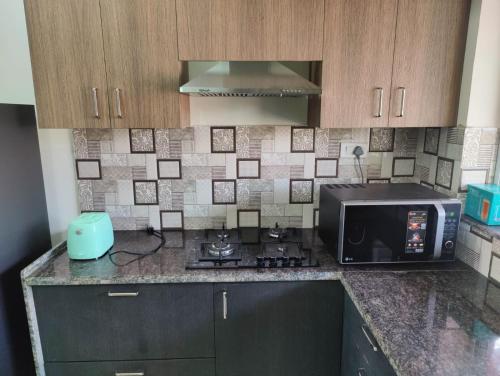 a kitchen with a microwave and a stove in it at Stays4you in Baga