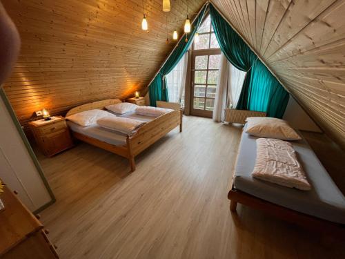 um quarto no sótão com 2 camas e um tecto de madeira em Ferienhaus 33 Altmühlthal em Kinding
