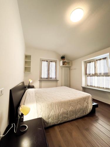 een slaapkamer met een groot bed en 2 ramen bij La casa di Prit in Roccasparvera