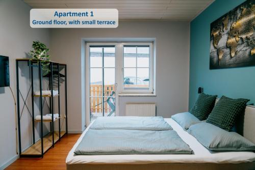 um quarto com uma cama e uma grande janela em Mountain View Salzburg Apartments em Grödig