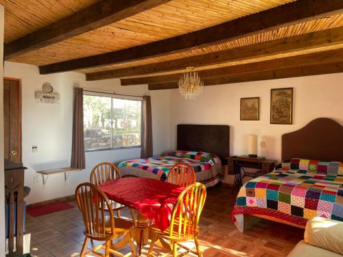 a room with two beds and a table and chairs at Ventana Al Desierto in Real de Catorce