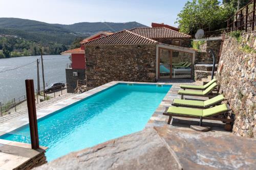 - une piscine avec des chaises longues à côté d'une maison dans l'établissement Quinta Torres de Azevedo by North Star Flats, à Sebolido