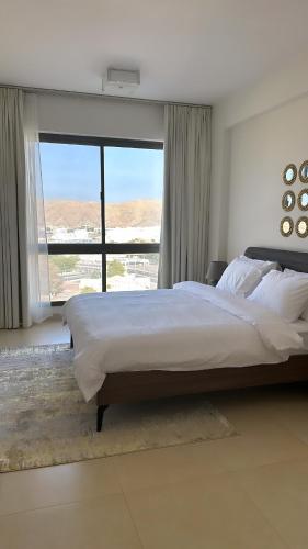 a bedroom with a large bed and a large window at Elegant 3-Bed room Sea-View in Muscat