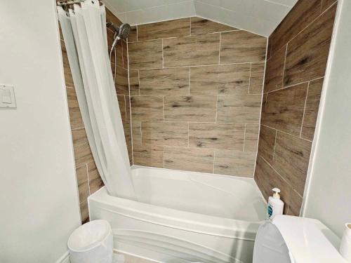 La salle de bains est pourvue d'une baignoire blanche et de toilettes. dans l'établissement Beautiful Room at Yonge and Sheppard and North York Centre, à Toronto