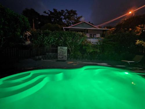 a green glow in the dark swimming pool at night at Les Kréol'inns in Saint-Leu