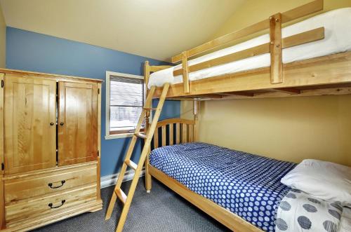 a bedroom with two bunk beds and a ladder at 16 Chemin Alpin in Stoneham