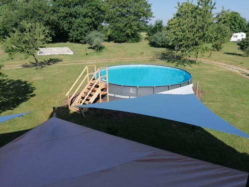 uma vista sobre uma piscina com uma tenda em Gite Pays de Joie 