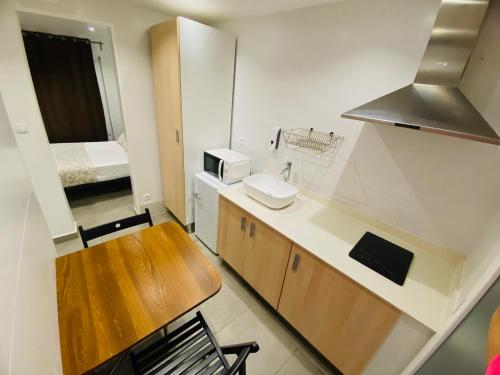 una pequeña cocina con fregadero y mesa en Apartamentos LH frente al metro Barcelona-Aeropuerto, en Hospitalet de Llobregat