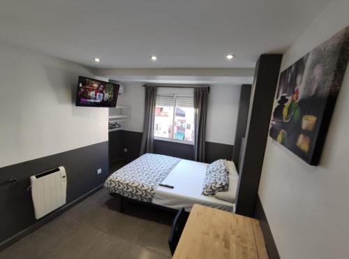 Habitación pequeña con cama y TV. en Apartamentos LH frente al metro Barcelona-Aeropuerto, en Hospitalet de Llobregat