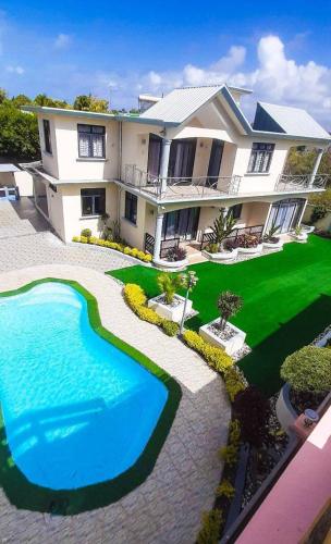 uma casa grande com piscina no quintal em Kevin Behary residence em Goodlands