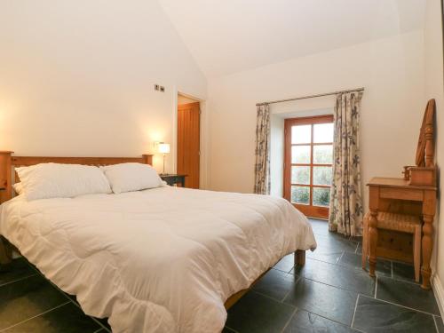 a bedroom with a large bed and a window at The Old Dairy in Pwllheli