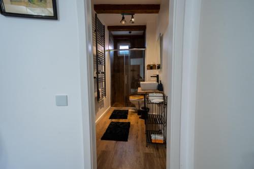 a hallway with a hallway leading into a bathroom with rugs at Middle Apartments in Braşov