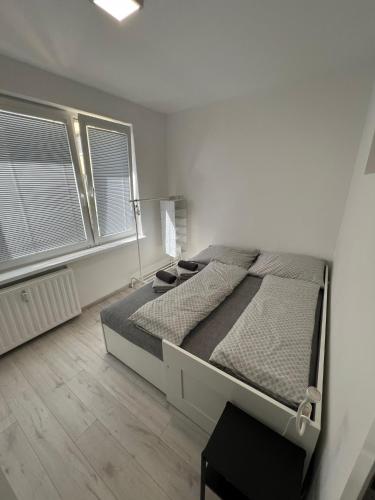 a bedroom with a large bed and two windows at Apartmán u Lukáša in Žilina