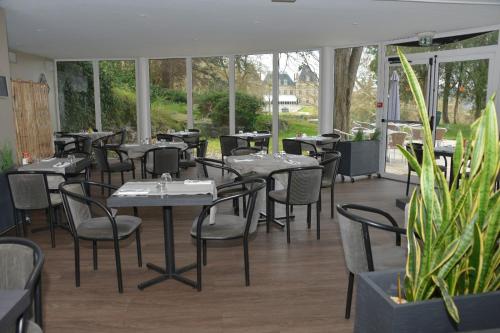 un restaurante con mesas, sillas y ventanas en Best Western Golf d'Albon, en Albon