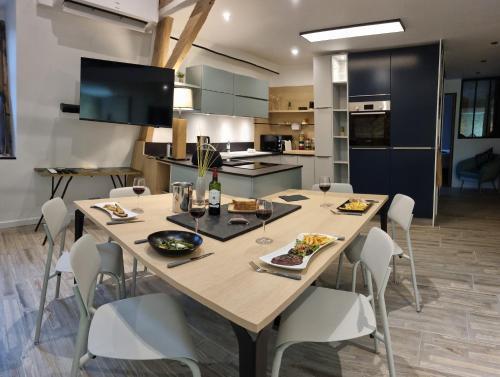 une cuisine et une salle à manger avec une table et de la nourriture. dans l'établissement Appartement avec Terrasse & Parking Sarlat centre, à Sarlat-la-Canéda