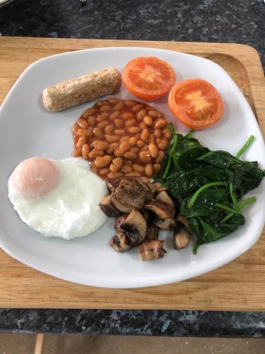 eine weiße Platte mit Bohnen und Tomaten in der Unterkunft Knoll Guest House in Cromer