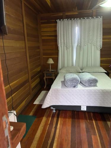 a bedroom with a bed with two pillows on it at Chalé Ipê Branco in Pedra Azul