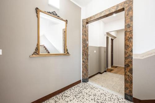 een spiegel aan de muur in een hal met een trap bij Cucchiari Suite 2 Tipo in Modena