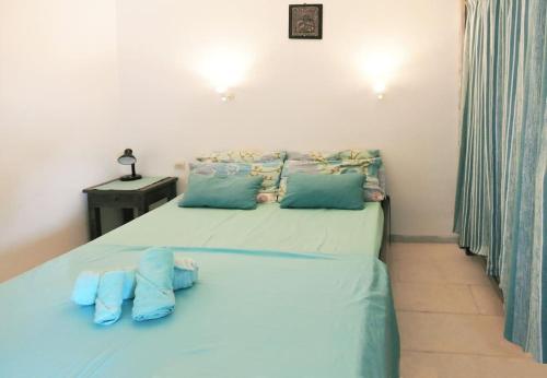 een slaapkamer met een bed met twee blauwe kussens bij Teal Blue Serenity in Agiassos