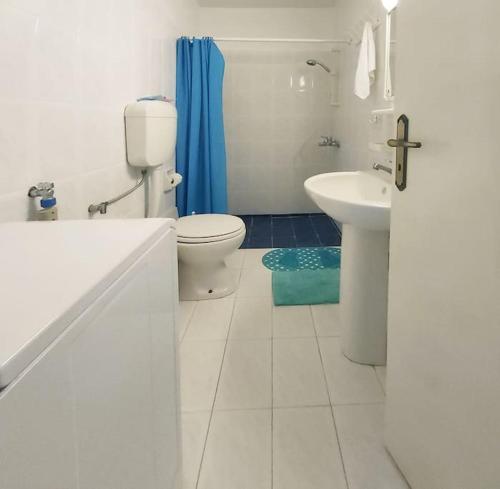 een witte badkamer met een toilet en een wastafel bij Teal Blue Serenity in Agiassos