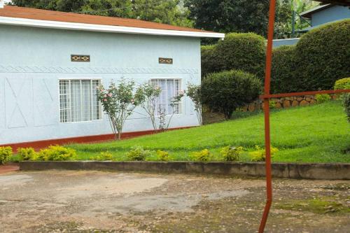 una casa blanca con flores en el patio en Inkindi House en Kigali