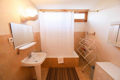 une salle de bain avec une baignoire et un lavabo dans l'établissement Le Rosenay, à Annecy