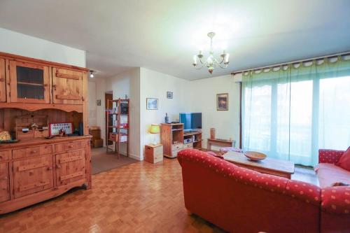 un salon avec un canapé rouge et une table dans l'établissement Le Rosenay, à Annecy