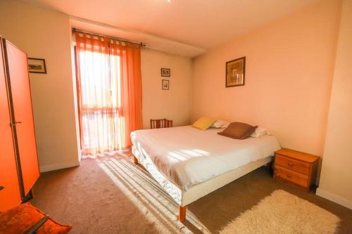 une chambre avec un lit et une grande fenêtre dans l'établissement Le Rosenay, à Annecy