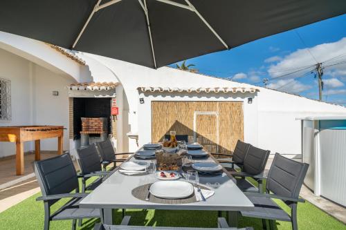 a dining room with a table and a piano at Host Wise - Sunny Spacious House - Terrace & Free Parking in Lagoa
