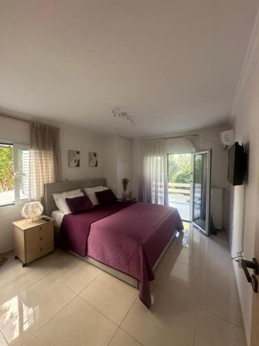1 dormitorio con 1 cama con colcha púrpura en Luxury Varkiza Apartment, en Varkiza