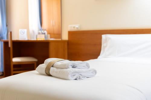 a pile of towels sitting on top of a bed at Alda Plaza Mayor Toro in Toro