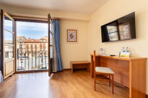 una camera con scrivania e ampia finestra di Hotel Zaravencia Plaza Mayor by InsideHome a Toro
