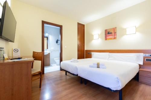 a hotel room with a large bed and a bathroom at Alda Plaza Mayor Toro in Toro