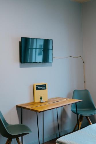 a table with two chairs and a tv on the wall at Mountain View Salzburg - SELF CHECK-IN - Apartments in Grödig