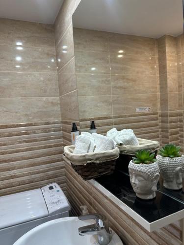een badkamer met een wastafel, een toilet en een spiegel bij Luxury Varkiza Apartment in Varkiza