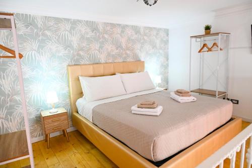 ein Schlafzimmer mit einem Bett mit zwei Handtüchern darauf in der Unterkunft Victry's Houses Chiaia in Neapel