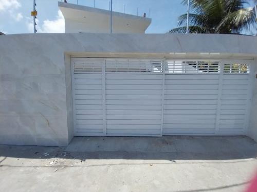 a garage with two doors on the side of a house at Casa Pitanga in Olinda