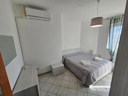 ein kleines Schlafzimmer mit einem Bett und einem Fenster in der Unterkunft Ariosto House in Porto Cesareo