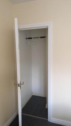 a room with a closet with a white door at Cosy Fermanagh Home - The Cosy Beech in Lisnaskea