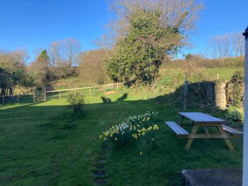 a picnic table in the middle of a field with flowers at Courtyard Cottage - Grade II listed - Barnstaple in Barnstaple