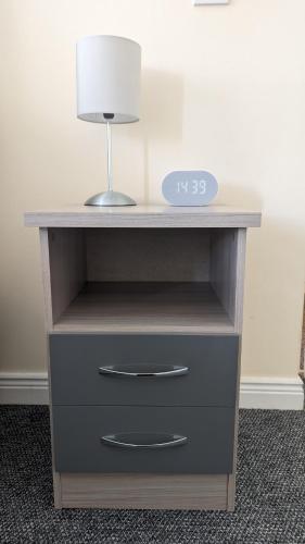 a desk with a lamp and a clock on it at Cosy Fermanagh Home - The Cosy Beech in Lisnaskea