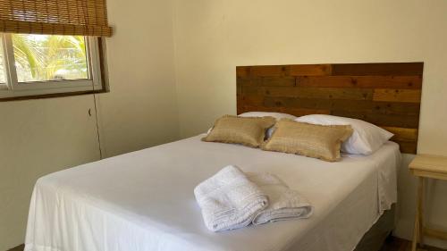 a white bed with two towels on top of it at Coco Beach in El Paredón Buena Vista