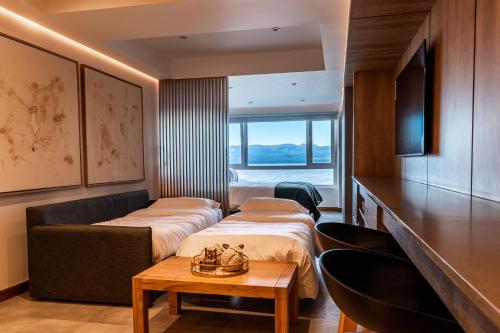 Habitación de hotel con 3 camas y mesa en Lake Inn - Departamentos con costa de Lago en San Carlos de Bariloche