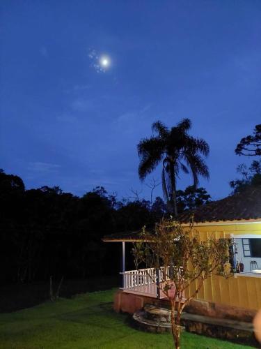 a house with a porch and a moon in the sky at Seu Refúgio com Lareira Próximo ao Petar in Apiaí