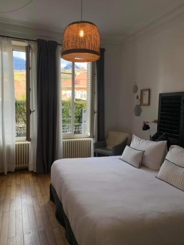 a bedroom with a large white bed and a window at les chambres de pauline in Albertville