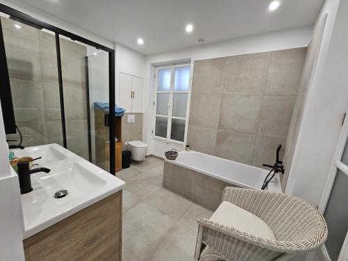 a bathroom with a sink and a tub and a toilet at La maison élégante, chambre proche gare et centre de Brunoy in Brunoy