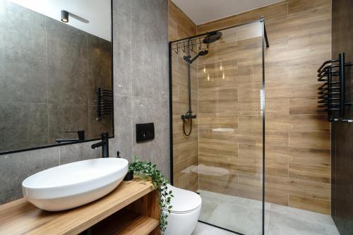 a bathroom with a white sink and a shower at Apartamenty i Pokoje Złote Piaski in Jastrzębia Góra
