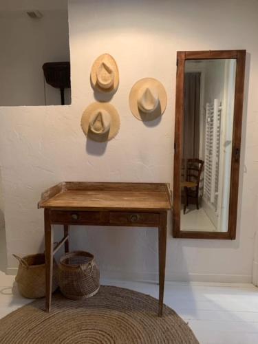 a mirror and a table with hats on a wall at Les chambres de Pauline avec spa et climatisation parking moto garage vélo in Albertville